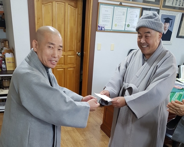경북동부교구 종회의장 지공스님이 지진 피해를 입은 법주사 주지 혜주스님(사진 오른쪽)에게 위로성금을 전달하고 있다.