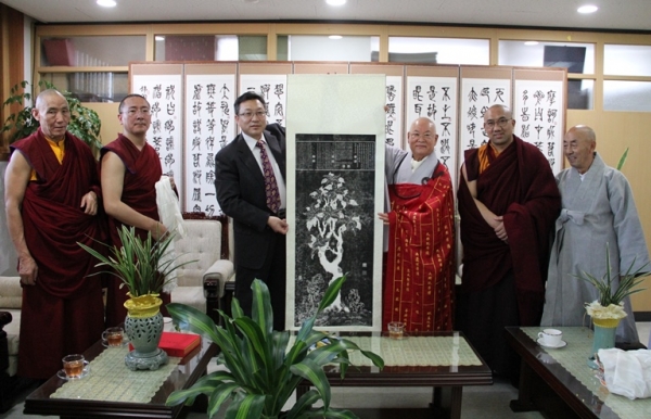 ‘중국시짱어(티베트어)고급불교대학’ 대표단이 총무원장 편백운 스님에게 예방 기념 판화족자를 전달하고 있다.