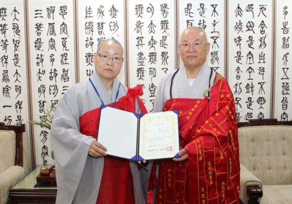 총무원장 편백운 스님으로부터 명예기자 임명장과 기자증을 받은 서울중서부교구 일인스님(사진 왼쪽).