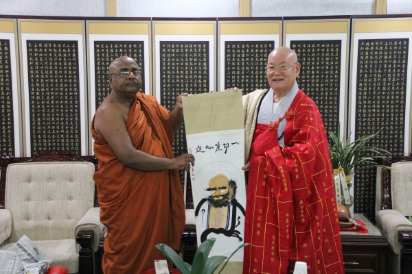 편백운 촐무원장스님이 인도불교 사무총장스님에게 달마도를 선물하고 있다.