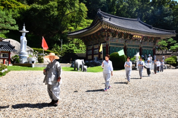 빨간색 깃발을 올리면서 걷고 있는 법정스님과 신도님들.