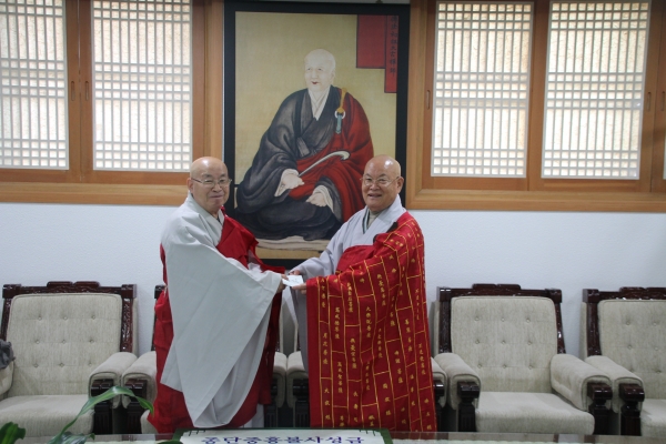 통합 부산교구 신임 종무원장 자관스님이 편백운 총무원장스님에게 종단발전성금을 전달하고 있다.