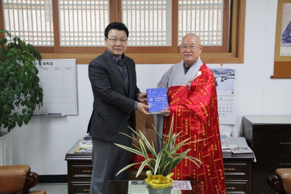 김진선 전 강원도지사가 편백운 총무원장스님에게 평창실록을 증정하고 있다.