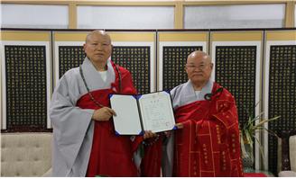 신임 총무부장으로 임명된 청보스님이 임명장을  받고 편백운 총무원장스님과 기념촬영.