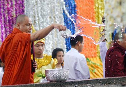 미얀마 스님이 한 불자에게 물을 부어서 정화의식을 하고 있다.