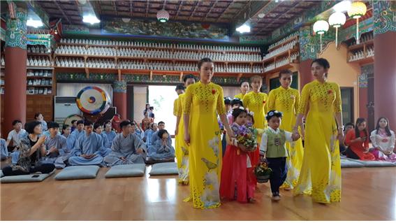 베트남 여성 불자와 화동들이 부처님께 꽃바구니를 공양하기 위해서 불단으로 행하고 있다.