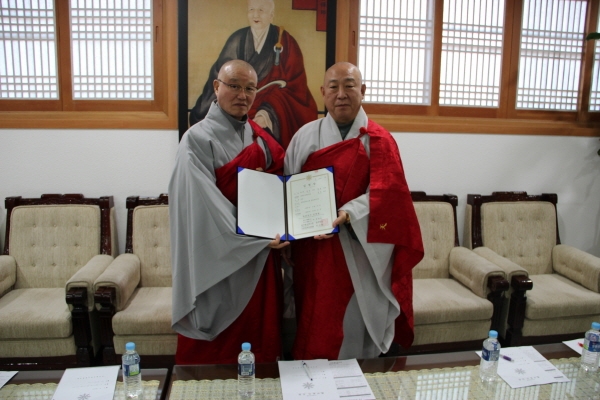 총무원장 호명 스님이 신임 동방불교대학 학장 상진 스님에게 임명장을 수여한 후 기념촬영을 하고 있다.