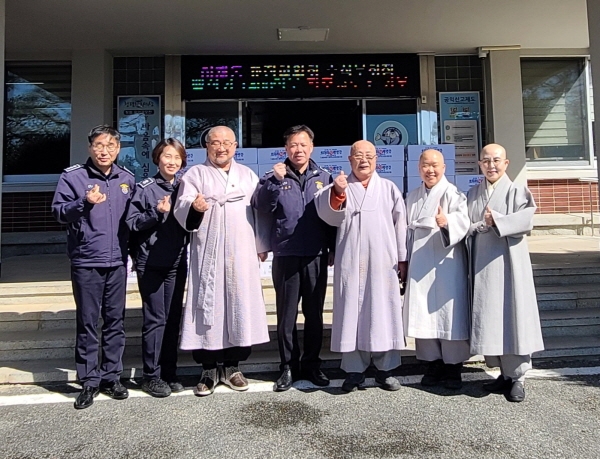 전북교구종무원장 진성 스님을 비롯한 임원단이 전주교도소 관계자들에게 수용자를 위한 백설기를 전달하고 기념사진을 찍고 있다.