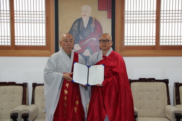 총무원장 호명 스님이 법연 스님에게 홍보국장 임명장을 수여한 후 기념사진을 찍고 있다.