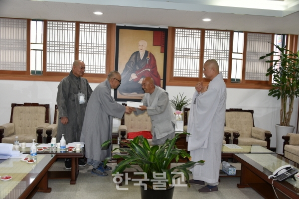 태경회 회장 법신 스님이 총무원 부원장 성오 스님에게 종단발전 성금을 전달하고 있다.