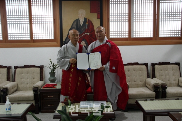 총무원장 호명 스님이 도우 스님에게 규정국장 임명장을 수여한 후 기념사진을 찍고 있다.