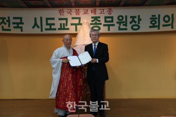 한국불교태고종 전국신도회장 임명장을 받은 배석영 씨가 총무원장 호명 스님과 기념촬영을 하고 있다.