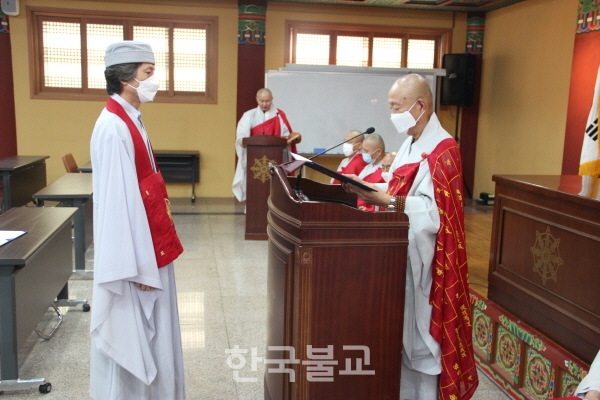 총무원장 호명 스님이 수교 대표자 김성수(해강) 전법사에게 품서증을 전달하고 있다.