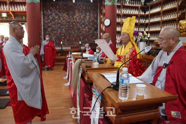 전계아사리 수진 스님이 수계자 대표 법경 스님에게 계첩을 수여하고 있다.