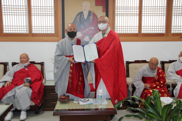 총무원장 호명 스님이 교무국장 진광 스님에게 임명장을 전달한 후 기념사진을 찍고 있다.