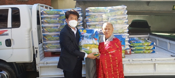 성해 스님이 서대문 요양센터 김희철 원장에게 자비의 쌀을 전달하고 있다.