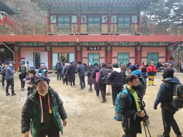 일출을 보기 위해 관암사를 찾은 시민들이 줄을 서 차례대로 절에서 나누어주는 떡국과 김밥을 받고 있다.