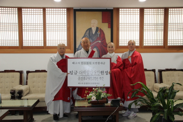 동방불교대 2학년 학인 대표들이 총무원장 호명 스님에게 태고사 인수불사 성금을 전달하고 있다.