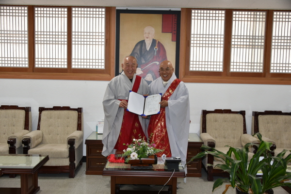 태고사 주지로 임명된 지성 스님이 임명장을 받은 후 총무원장 호명 스님과 함께 기념사진을 찍고 있다.