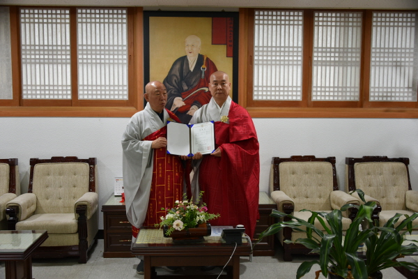 총무원장 호명 스님이 불교문예원 사무국장 혜담 스님에게 임명장 수여 후 기념사진을 찍고 있다.
