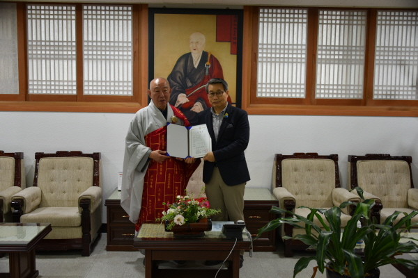 총무원장 호명 스님이 총무원장 종책특보 이상곤 씨에게 임명장을 전달한 후 기념사진을 찍고 있다.