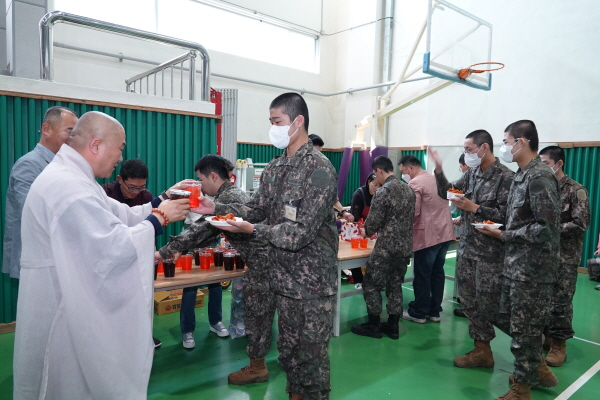 진성 스님이 장병들에게 간식과 음료를 나눠주고 있다.