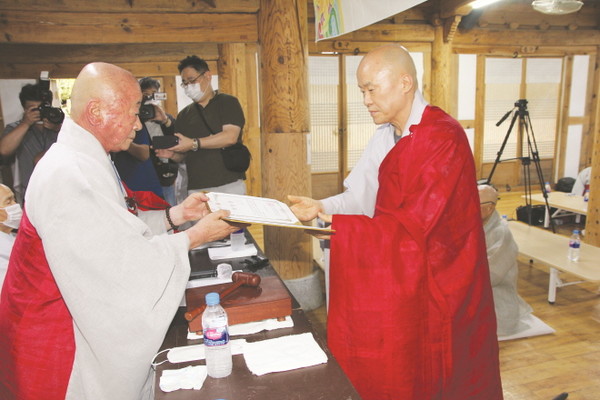 선거관리위원장 현호 스님으로부터 당선증을 받고 있는 승범 스님.(사진 오른쪽)