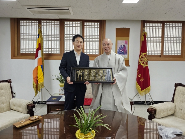 총무원장 상진 스님이 정용옥 문체부 종무실장에게 목판 반야심경을 선물하고 기념촬영을 하고 있다.