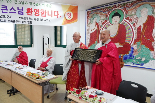총무원장 상진 스님이 전북교구 종무원장 진성 스님에게 반야심경 목판본을 선물하고 있다.