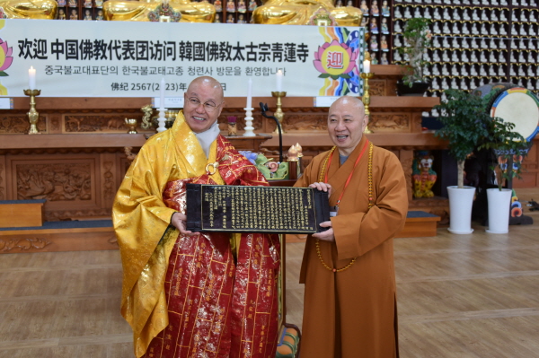 총무원장 상진 스님이 목판 반야심경을 중국불교협 부회장 밍싱 스님에게 선물하고 있다.