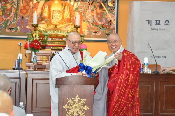 총무원장 상진 스님이 제16대 중앙종회 전반기 의장에 선출된 시각 스님에게 축하 꽃다발을 전해주고 있다.