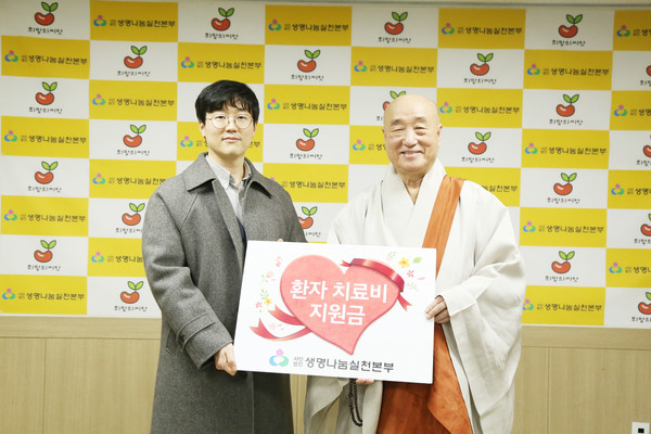 일면 스님(오른쪽)이 김지민 환자를 대신해 참석한 담당 의료사회복지사에게 치료비를 전달했다.