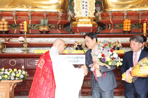 한국불교태고종 총무원장 상진 스님이 이관섭 대통령실 불자회 회장에게 꽃다발을 전달한 후 축하인사를 건네고 있다.