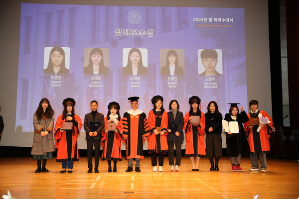 윤재웅 동국대 총장(왼쪽에서 5번째)이 성적우수상 수상자들 및 가족들과 기념사진을 촬영하고 있다.
