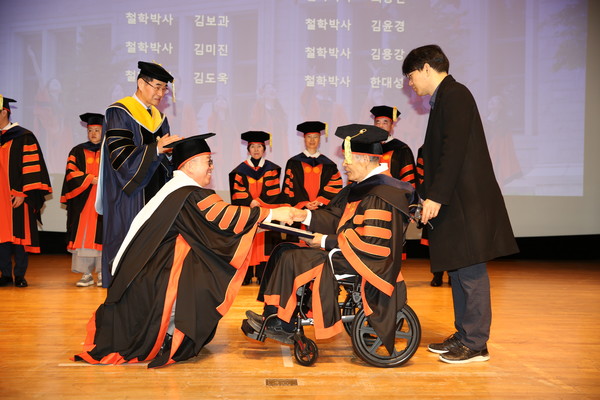 윤재웅 동국대 총장(맨 앞 왼쪽)이 박사 학위수여자에게 학위를 수여하고 있다.
