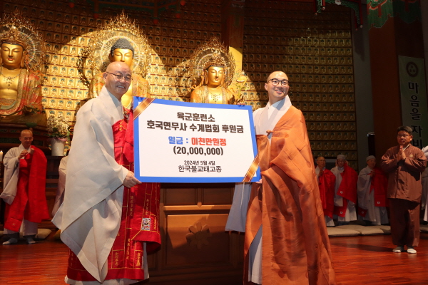 총무원장 상진 스님이 논산훈련소 훈련병 격려금 2천만 원을 호국연무사 주지 진오 스님에게 전달하고있다.