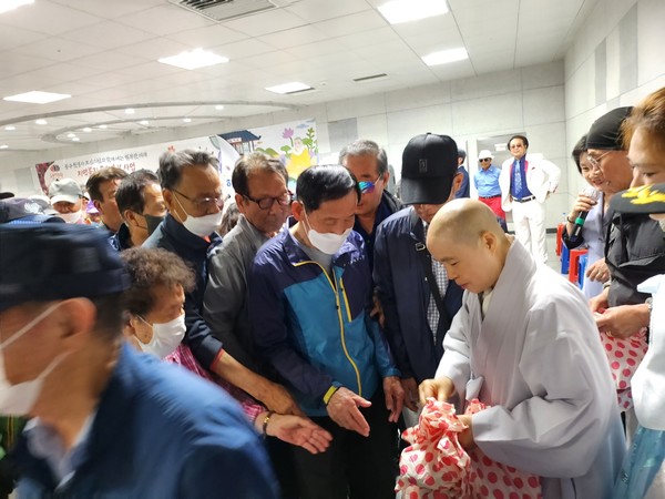 천명사 보신 스님이 어르신들에게 직접 만든 연잎밥과 음료수를 나누고 있다.