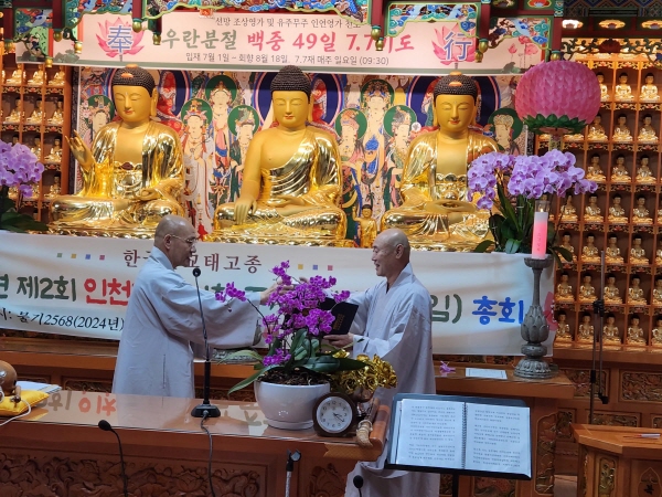 중앙원로의원으로 선출된 능화 스님이 자신의  사퇴로 보궐선거에서 중앙종회의원과 교구 지방종회의장에 선출된 혜천 스님에게 당선증을 전달하고 있다.