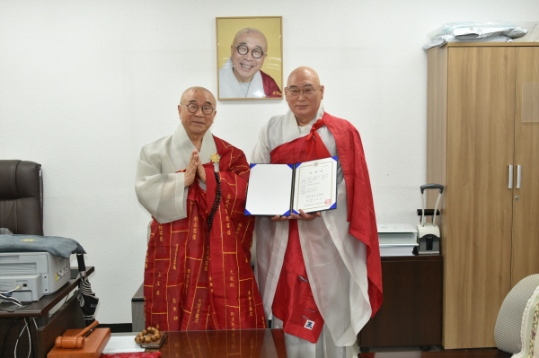 호법원장 혜일 스님이 초심위원 만송 스님에게 임명장을 전달한 후 기념촬영을 하고 있다.