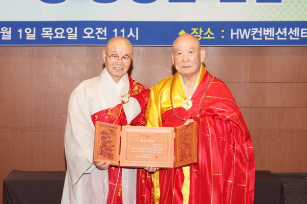 총무원장 상진 스님이 승정 금용 스님에게 추대패를 전달한 후 기념촬영을 하고 있다.