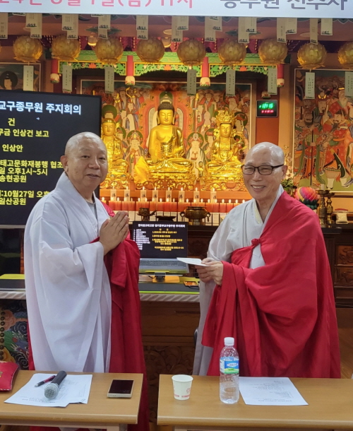 경기중부교구 지방종회의장 법헌 스님이 종무원장 지허 스님에게 성금을 전달하고 있다.