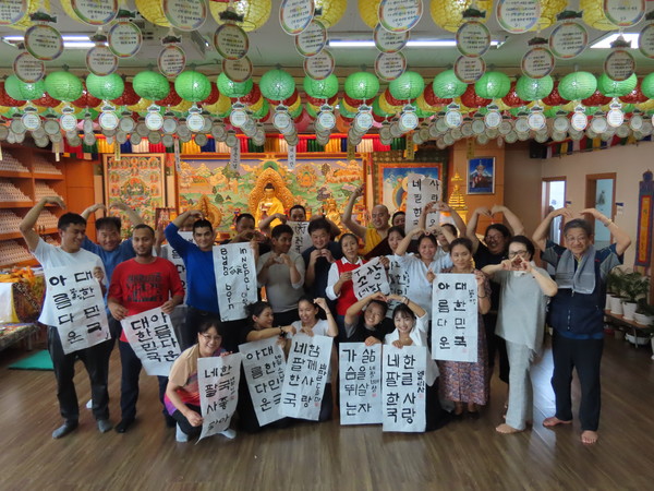 네팔 이주민 불자들이 직접 쓴 한글 서예작품을 들고 기념 촬영을 하고 있다.