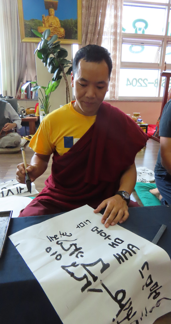 네팔 니마 스님이 한글과 티벳어로 옴마니뻬메훔을 써보며 즐거워하고 있다.