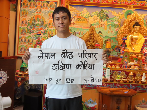 네팔 이주민 불자 다와가 한글과 힌디어로 구성한 서예 작품을 선보이고 있다.