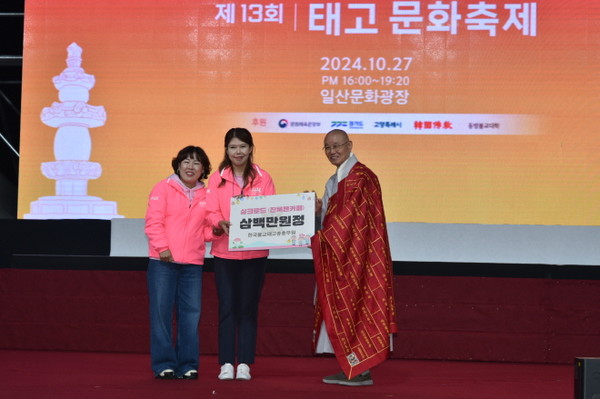 진욱 팬카페 회원들이 태고종 발전성금 3백만 원을 총무원장 상진 스님에게 전달하고 있다.