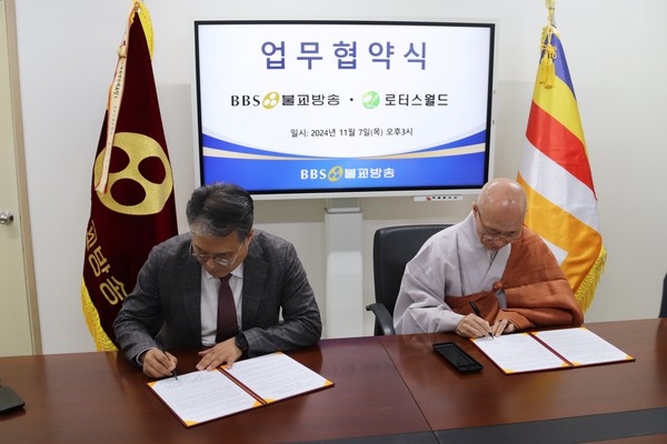 BBS 서진영 사장과 로터스월드 이사장 성관 스님이 업무협약서에 사인을 하고 있다.