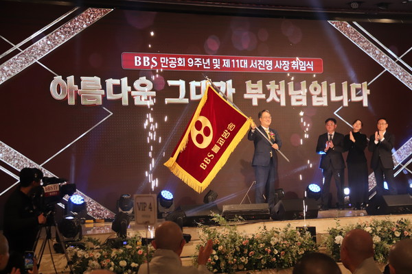 BBS불교방송 서진영 사장이 취임식에서 깃발을 전달받고 있다.