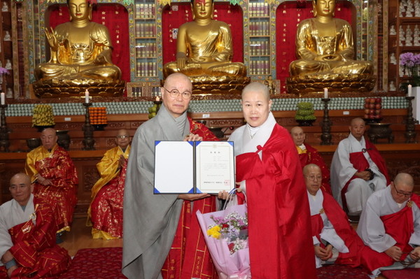 총무원장 상진 스님이 경기북부 지방종회의원 법경 스님에게 표창장을 전달한 후 함께 기념사진을 찍고 있다.