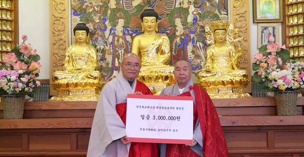 중앙원로의원 동우 스님이 종무원장 원철 스님에게 발전성금을 전달하고 있다.