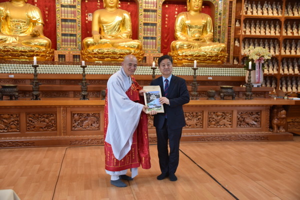 교육원장 재홍 스님이 정책 자료집을 김영배 민주당 대선후보 선거대책위 불교본부장에게 전달하고 있다.